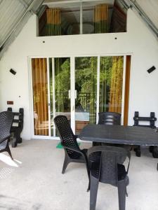 a black table and chairs on a patio at Rainforest River Cabana & Villa in Deniyaya