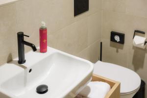 a bathroom with a white sink and a toilet at Haus Meeresstern in Wangerooge +45 photos