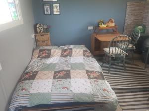 a bedroom with a bed with a quilt on it at Tiny living on the Wild Atlantic Way in Tralee