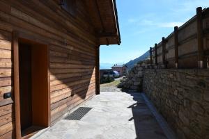 a building with a wooden wall next to a doorway at Chalet du Sky PILA in Cerise +11 photos