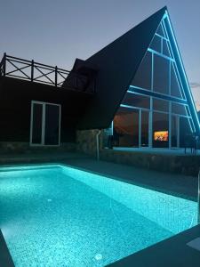 a swimming pool in front of a house at SkyHouse Shahdag in Əniq