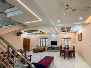 a living room with a table and chairs at Kattuvallil AGAPE Homestay 4B2HK in Thiruvalla