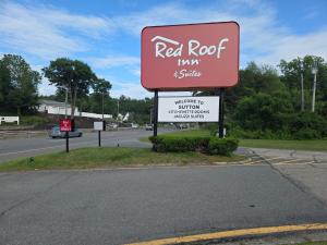 a red roof tavern and shuttle sign on the side of a road at Red Roof Inn Sutton in Sutton