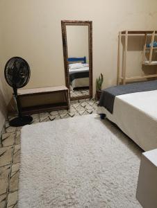 a bedroom with a bed and a mirror at SPA Alexandre Maia quarto 1 in Juazeiro do Norte