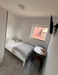a small bedroom with a bed and a small window at Domki CLAUDIA in Darłowo