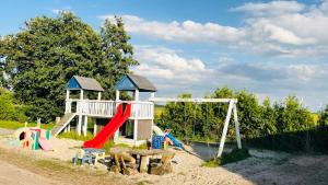 a playground with a slide and a play structure at Admiralshütte XXL - für 12 Personen zwischen Dornumersiel und Bensersiel in Dornum