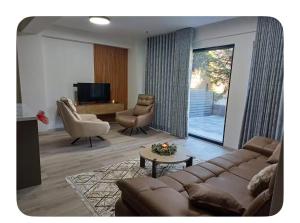 a living room with a couch and chairs and a television at Luxury aprtmans in Mavrovo