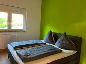a bed in a room with a green wall at Ferienhaus Louis Philippe in Altlay