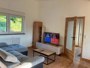 a living room with a couch and a flat screen tv at Ferienhaus Louis Philippe in Altlay