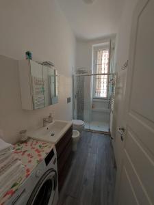 a white bathroom with a sink and a toilet at Appartamento viktor in Cislago