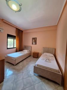 a bedroom with two beds and a window at Hotel Rossi in Vlorë
