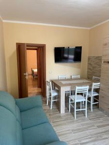 a living room with a blue couch and a table and chairs at Vale house in Monte San Biagio