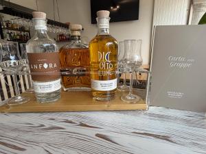 two bottles of alcohol on a wooden tray with glasses at La Locanda del Viandante in Mendrisio