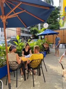 a group of people sitting at a table under an umbrella at Til Sunrise in Cali