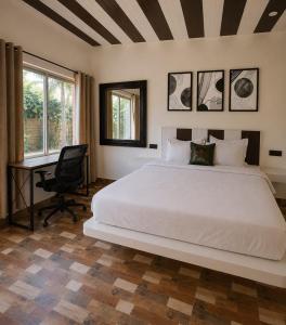a bedroom with a large white bed and a desk at Coco Nest Mandrem in Mandrem