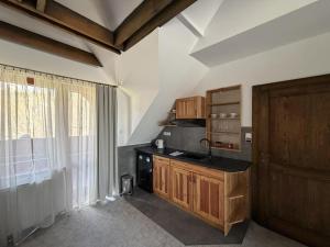 a kitchen with a sink and a stove top oven at Penzión SIMI in Tatranská Lomnica