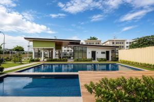 a swimming pool in front of a building at Modern Japandi Studio with Pool Near Mactan Airport in Bankal