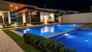 a swimming pool in front of a house at night at Modern Japandi Studio with Pool Near Mactan Airport in Bankal