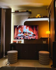 a living room with a flat screen tv on a wall at Modern Japandi Studio with Pool Near Mactan Airport in Bankal