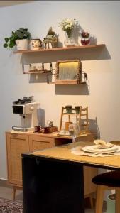a kitchen with a table with a coffee maker and shelves at Noya Chalet in Rumays +17 photos
