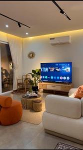 a living room with a white couch and a flat screen tv at Noya Chalet in Rumays