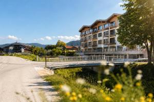 a bridge over a river next to a building at BASE Achensee - Opening August 2026 in Achenkirch