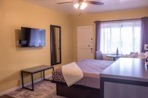 a bedroom with a bed and a flat screen tv at Carmel Wayfarer Inn in Carmel