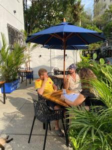 two men sitting at a table under an umbrella at Til Sunrise in Cali