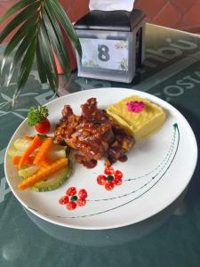 a plate of food with meat and vegetables on a table at Hotel El Bambu in Sarapiquí
