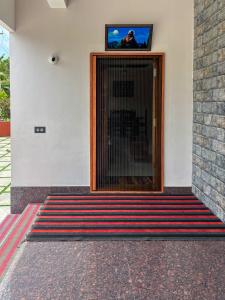 a door with a television on top of a building at Kattuvallil AGAPE Homestay 4B2HK in Thiruvalla