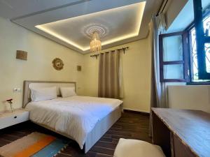 a bedroom with a white bed and a window at Dar Bleu Pearl in Chefchaouen