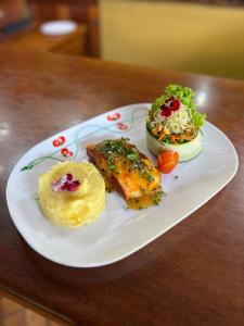 a white plate with food on a wooden table at Hotel El Bambu in Sarapiquí +11 photos