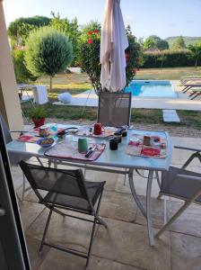 a table with two chairs and an umbrella next to a pool at le pavillon in Viré