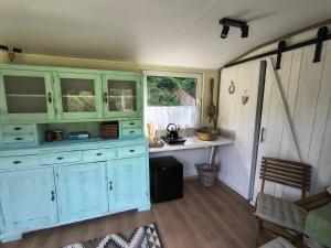 a kitchen with a blue cabinet and a table at Tiny House Zagroda Kopytkowo in Ropica Górna +9 photos