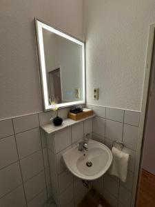 a bathroom with a sink and a mirror at Jade Villa an der Nordsee in Jaderaltendeich
