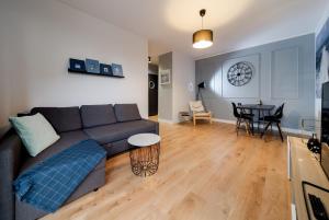a living room with a couch and a table at Lighthouse Apartment Nadmorze - 150 m od morza, ogródek, garaż in Gdańsk
