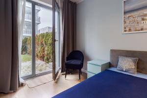 a bedroom with a bed and a chair and a window at Lighthouse Apartment Nadmorze - 150 m od morza, ogródek, garaż in Gdańsk +13 photos