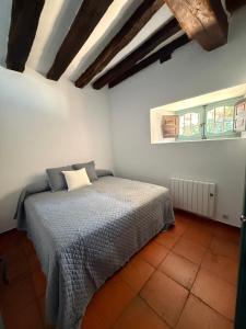 a bedroom with a bed and two windows at La Casuca in Riaza