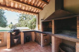 an outdoor kitchen with a large brick oven at El Corral in Lladurs