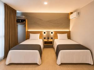 ein Zimmer mit zwei Betten in einem Zimmer in der Unterkunft Senoma Hotel - Adults only in Ica