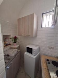 a kitchen with a microwave on top of a refrigerator at Il Carrubo in Massafra