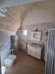 a bathroom with a white toilet and a sink at Il Carrubo in Massafra
