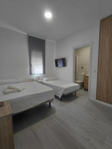 a room with two beds and a television in it at Corvera Guss in Corvera