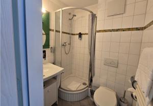 a bathroom with a shower and a toilet and a sink at Hotel AVIVA by APOLONIA in Karlsruhe +27 photos