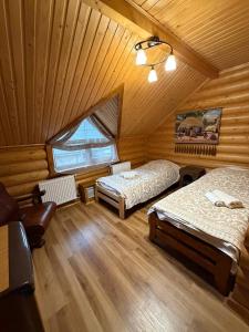 a bedroom with two beds in a wooden cabin at Дикий Кіт in Vorokhta