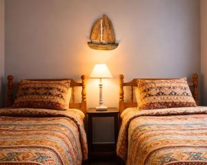 a bedroom with two beds and a lamp on a table at PRAIRIE SKY GETAWAY in Cheyenne +1 photo