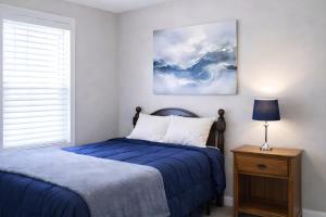 a bedroom with a blue bed and a window at PRAIRIE SKY GETAWAY in Cheyenne
