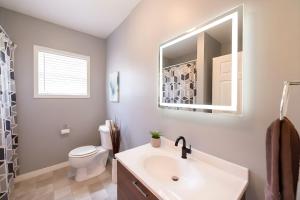 a bathroom with a sink and a toilet and a mirror at PRAIRIE SKY GETAWAY in Cheyenne