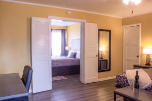 a room with a bedroom with a bed and a mirror at Carmel Wayfarer Inn in Carmel