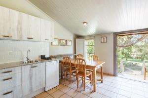 a kitchen with a table and chairs and a window at El Corral in Lladurs